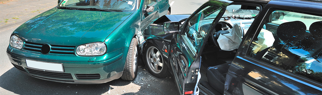 Zwei demolierte Fahrzeuge bei Unfall, Trümmer liegen auf Straße, KFZ-Gutachter untersucht Situation in Gütersloh.